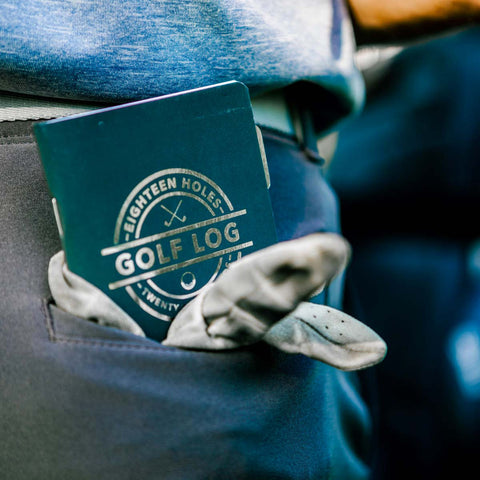 The pocket golf log is in the back pocket with a golf glove.