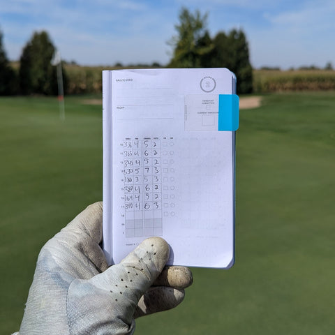 Holding up the second page of a filled-out golf log