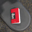 Red workout log book on a black gym bench with a speckled floor background